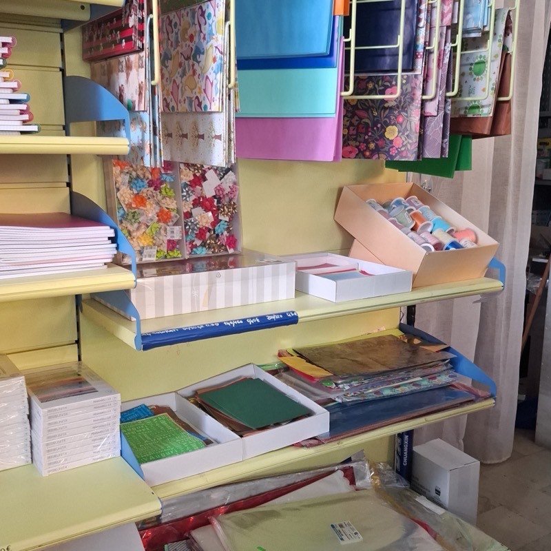 Carta da regalo e cartoncini colorati appesi al loro espositore