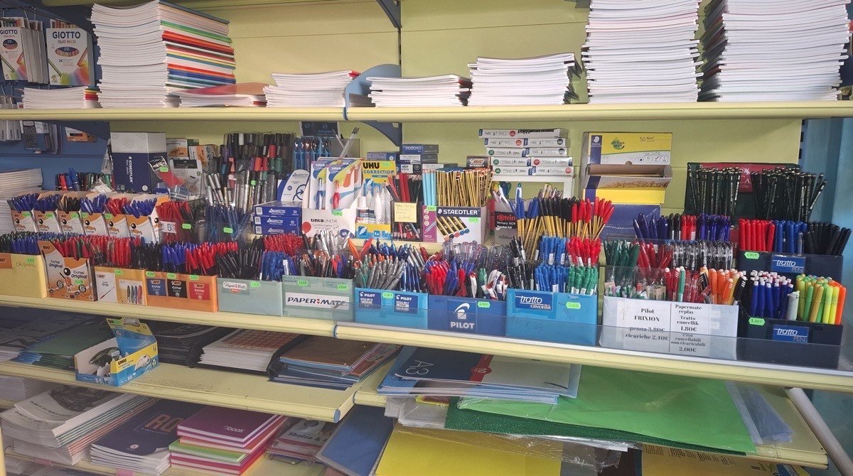 Gli scaffali di Cartolandia: quaderni, risme di carta e vaschette piene di penne Bic, Pilot e Staedtler