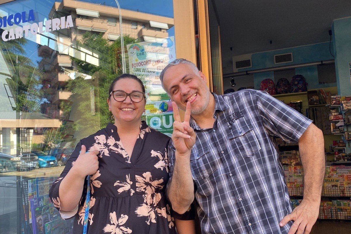 Daniela ed Enzo davanti alla vetrina di Cartolandia, sotto l’insegna Edicola Cartoleria