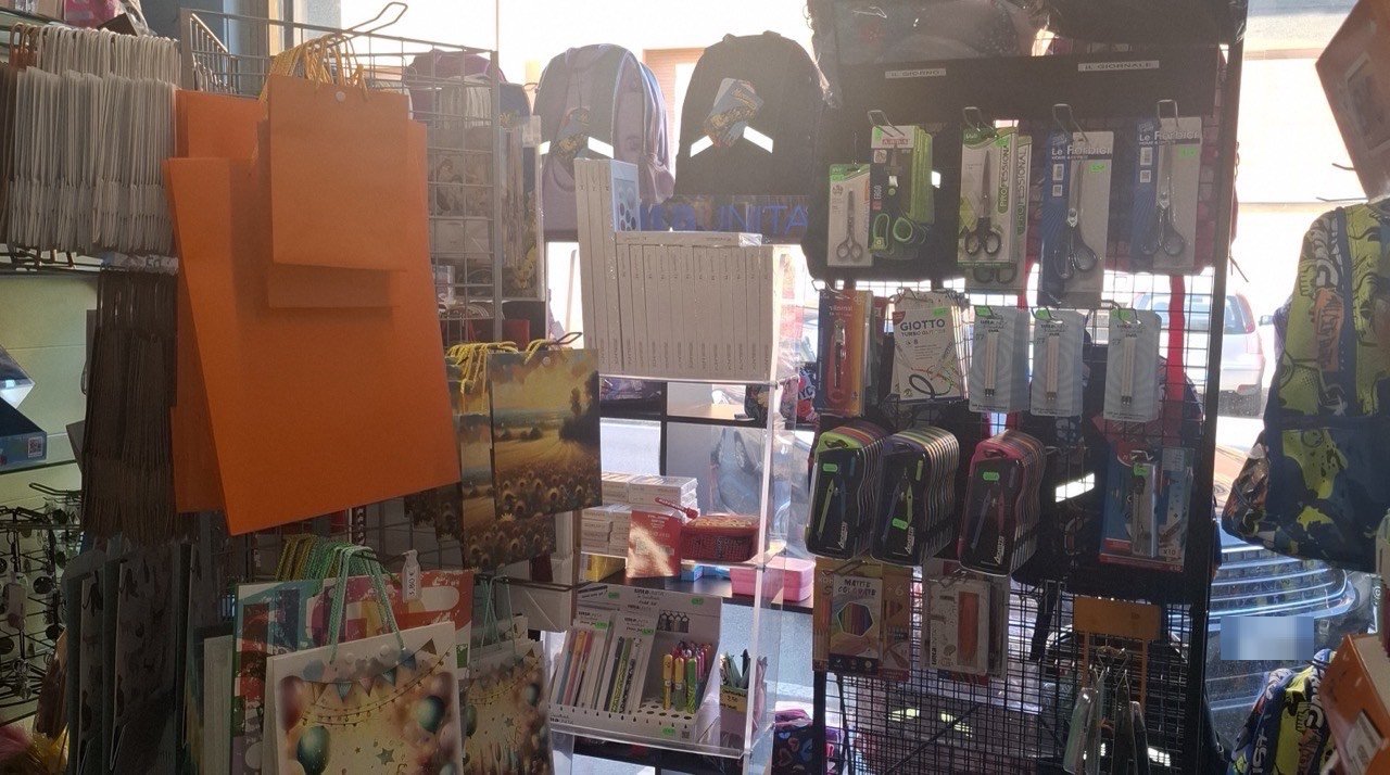 La vetrina vista da dentro: zaini, buste regalo e materiale per la scuola